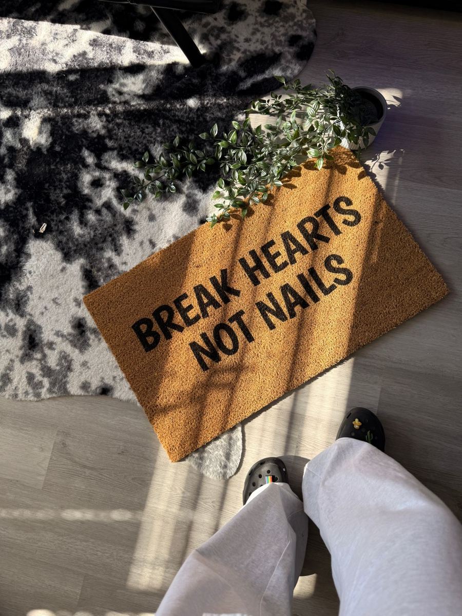 Doormat reading "Break Hearts Not Nails" at the studio entrance